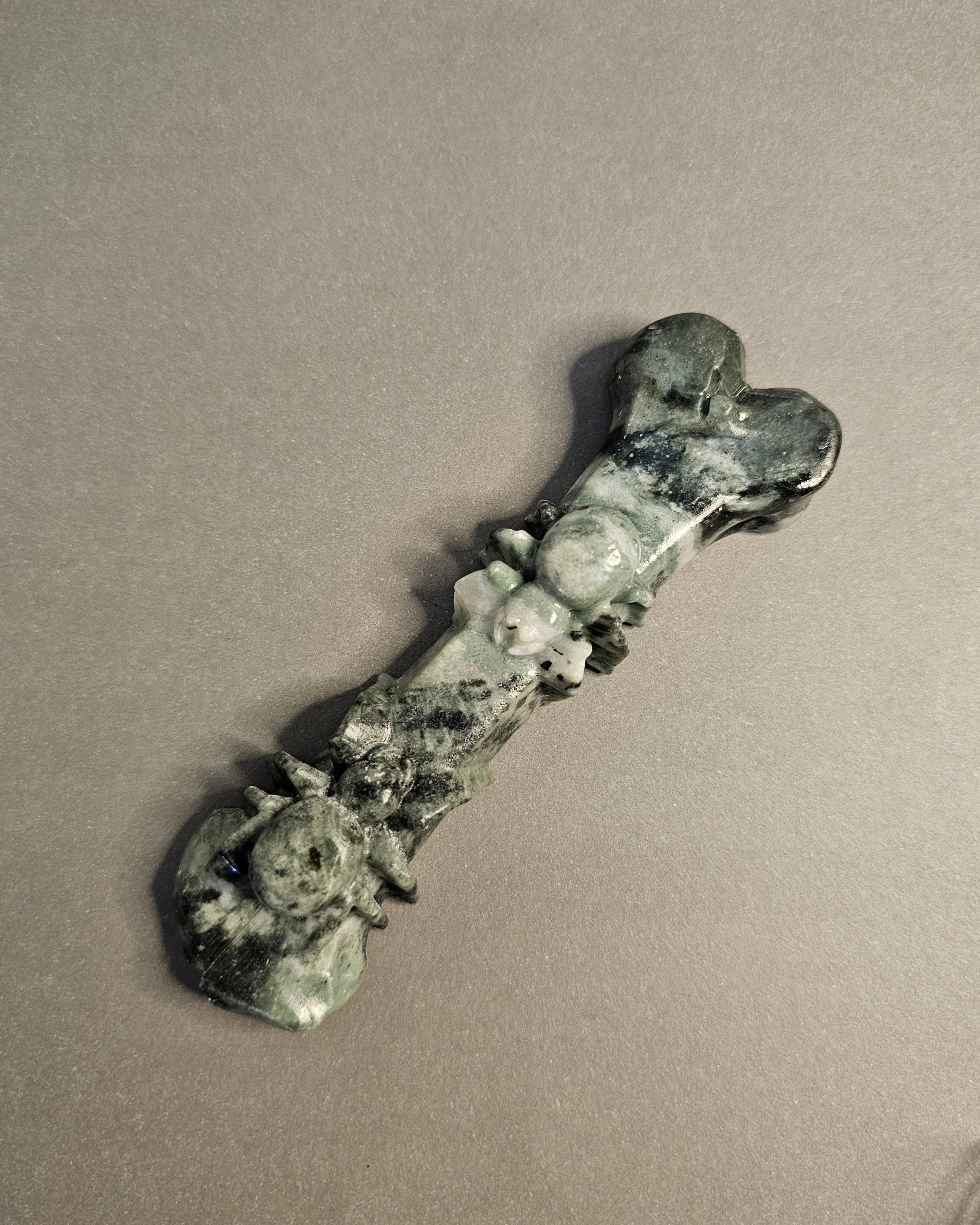 Jade bone carving with two spiders carved on it.