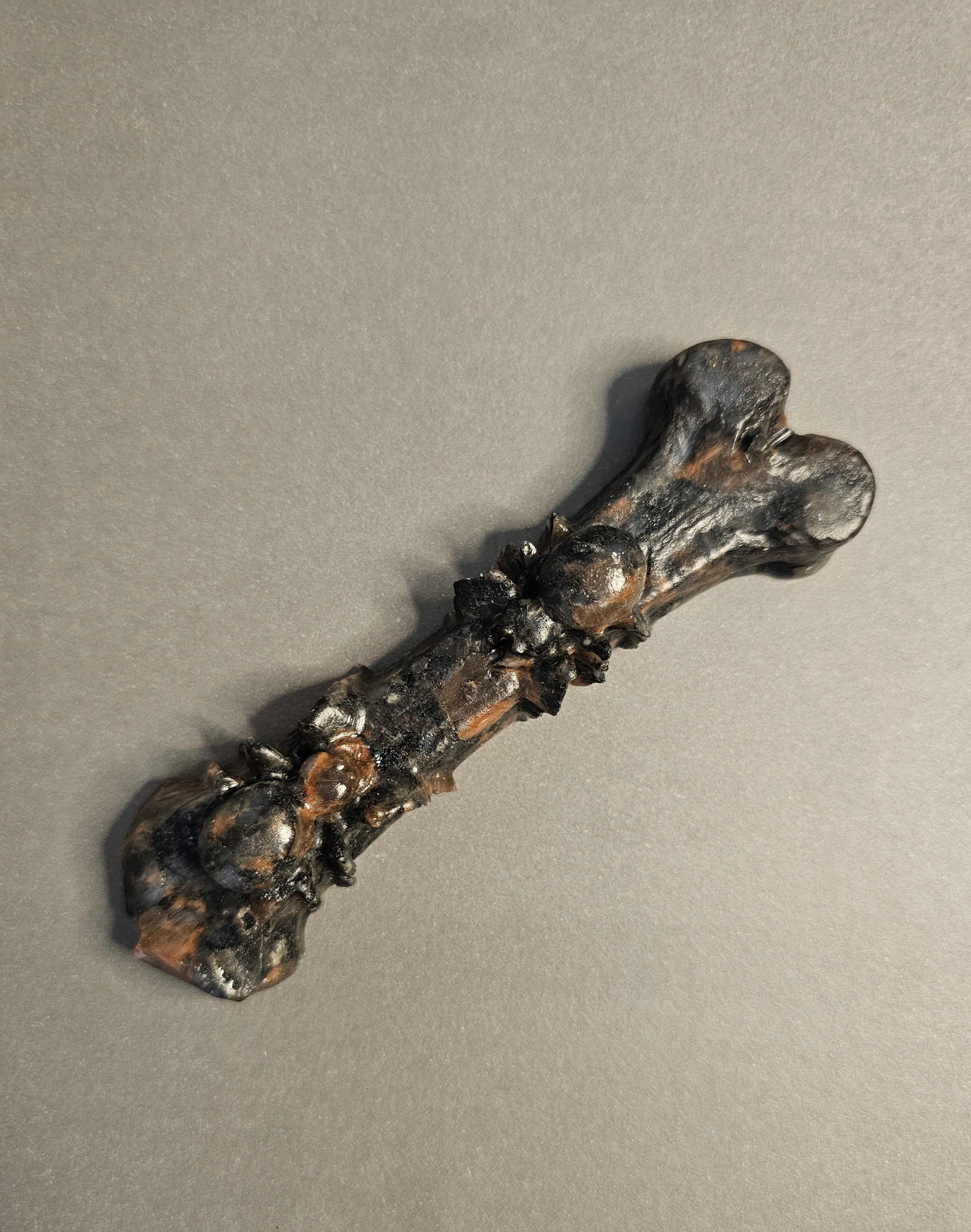 Red Que Sera bone carving with two spiders carved on it.